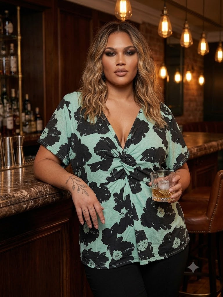 Woman in a floral Rocha John Rocha blouse holding a drink in a bar setting. Soft stretch jersey for fit and comfort