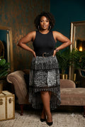 Woman in a stylish Beverly Drive skirt standing in an elegant room with decorative elements.