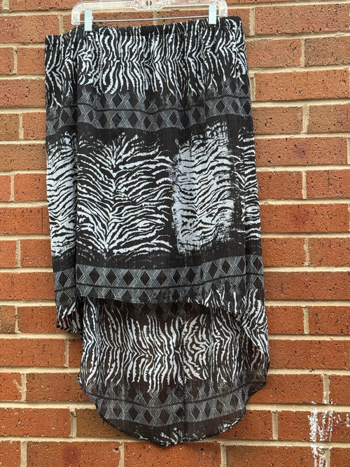 Beverly Drive plus size Skirt with zebra print and geometric patterns hanging against a brick wall.