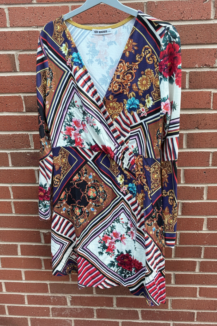 Colorful patterned dress by 101 Idees hanging against a brick wall