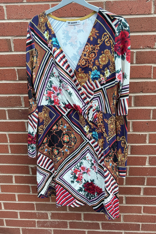 Colorful patterned dress by 101 Idees hanging against a brick wall