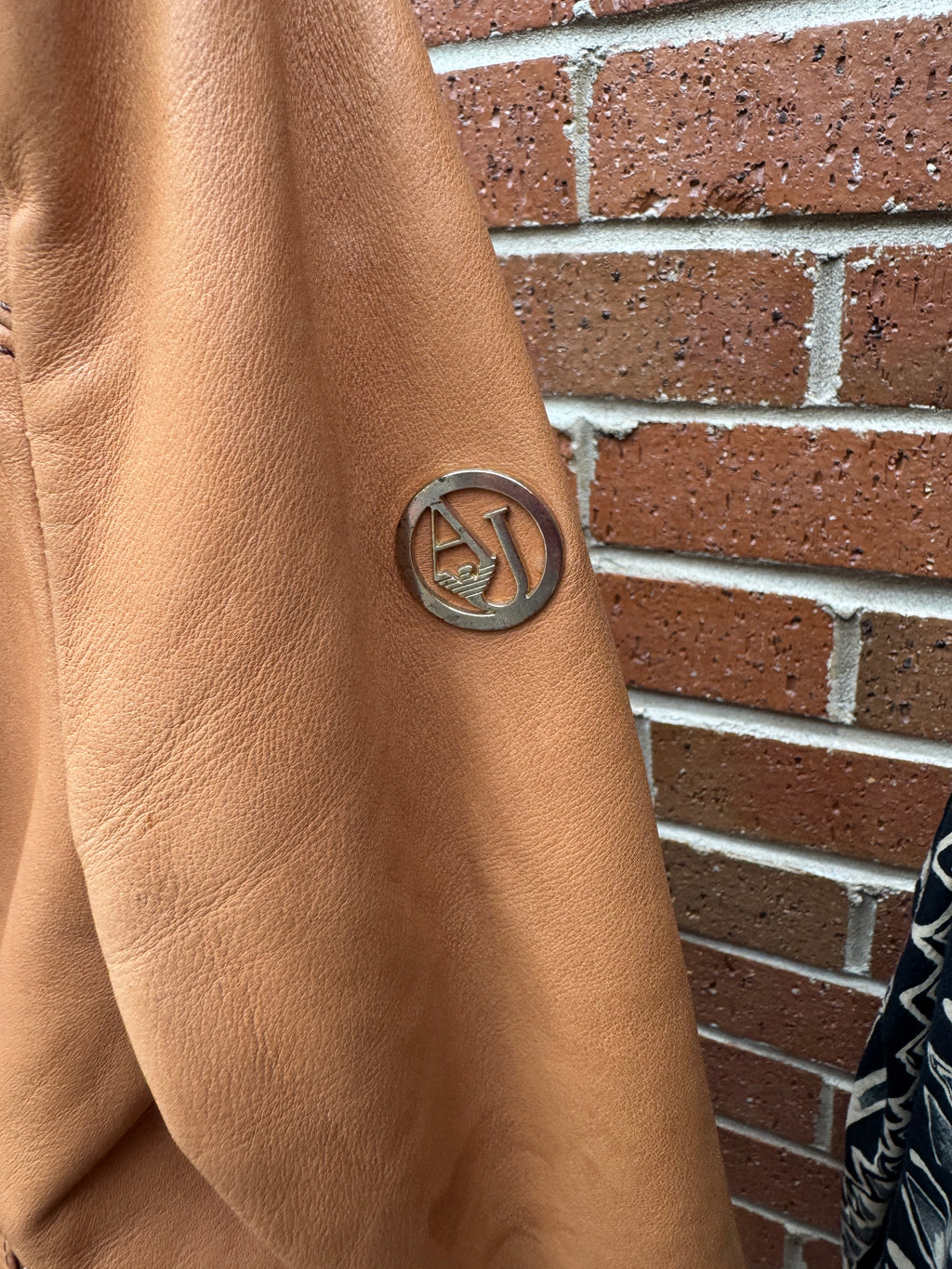 Close-up of a brown leather Armani Jeans  Jacket with AJ Logo
