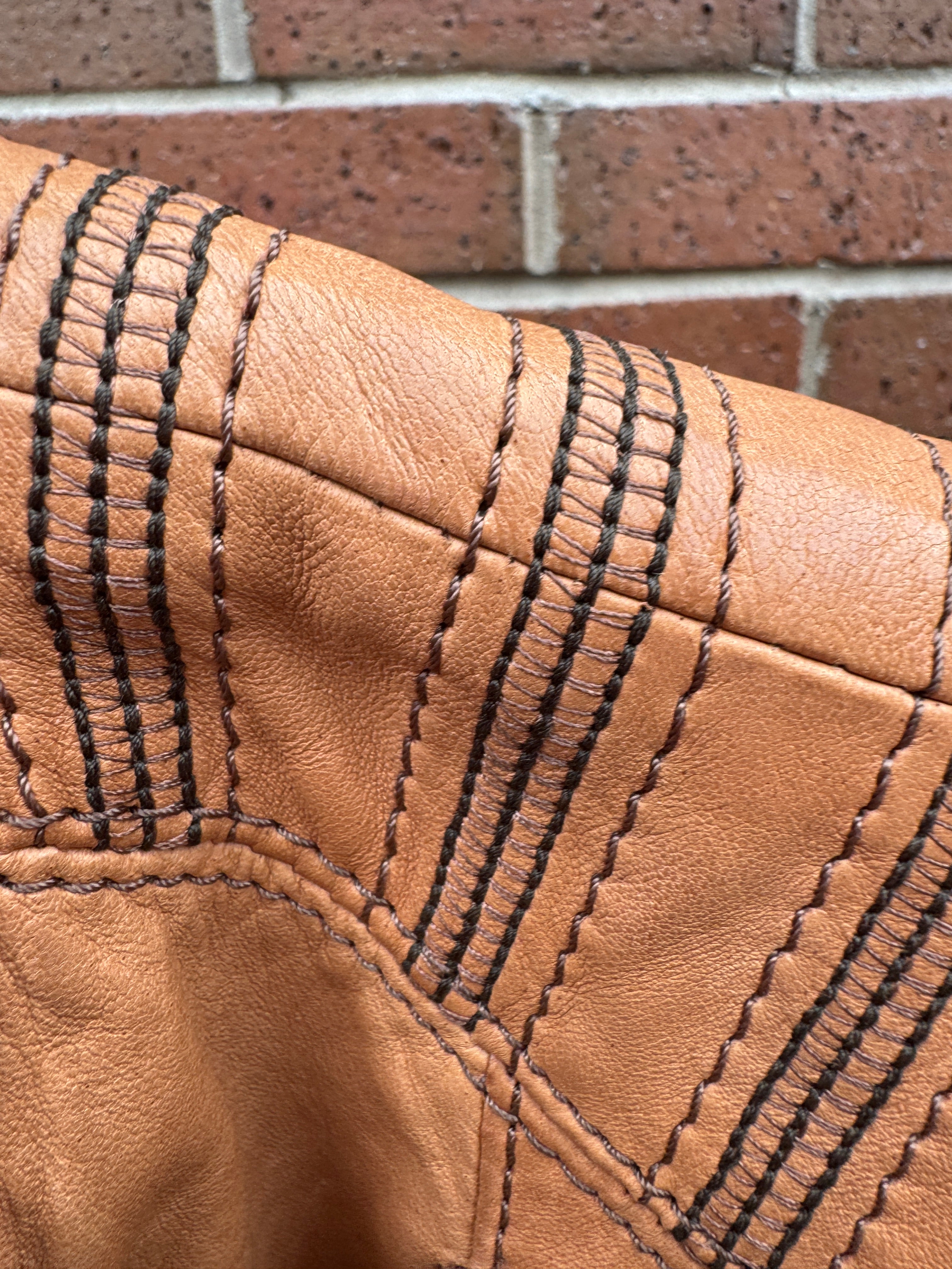 Close-up of brown leather Armani Jacket with black stitching