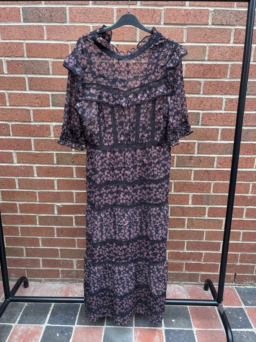 Floral-patterned dress on a hanger against a brick wall.